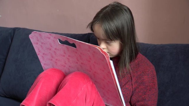 Down syndrome girl is drawing