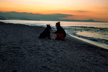 Woman on the beach with her best friend, German Shepard, Sunset at the Mediterranean Sea,