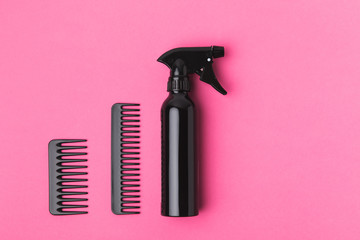 top view of black combs and spray, isolated on pink