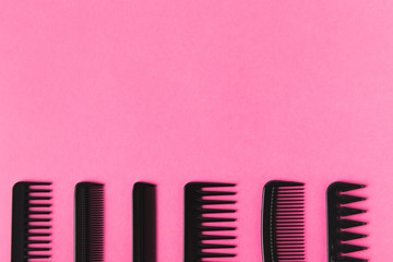 top view of black combs in row, isolated on pink with copy space