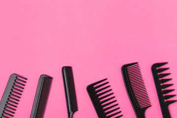 top view of black combs, isolated on pink