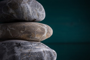 drei Steine gestapelt Steinmeditation links grüner Hintergrund horizontal