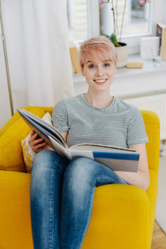 Attractive woman relaxing on a chair with a book