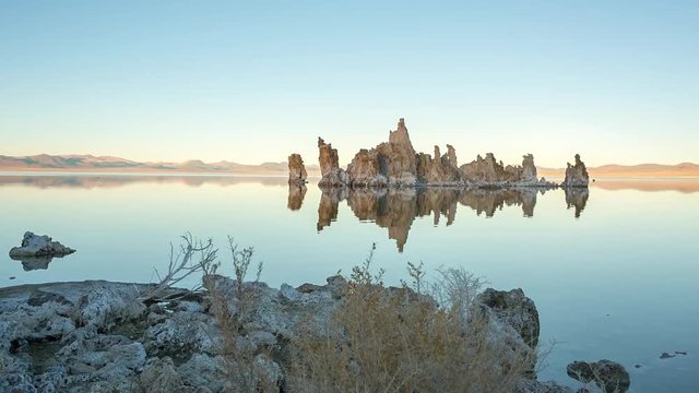 Mono lake tufas with reflection in calm water close-up on sunrise.