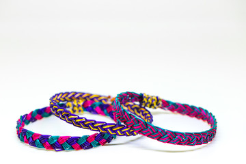 The extreme ordinary colorful bamboo wrist bands in the white background studio which made by hill tribe and can be seen in many places and no people holds the art copyright. 