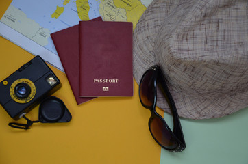 The concept of traveling on a background map. travel planning. top view of the traveler's accessories. two passports, a camera, sunglasses, a hat on the world map. travel preparation.