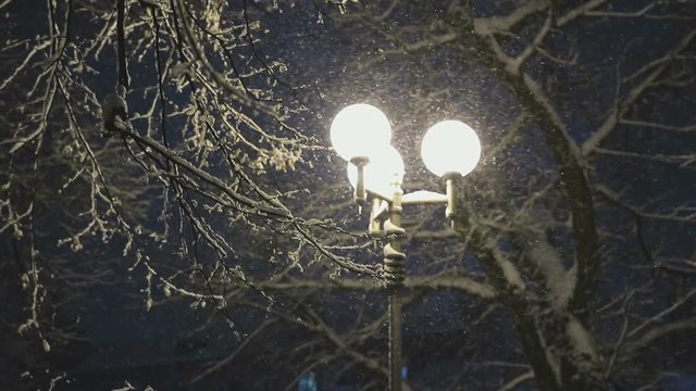 Bad weather, rain and sleet on the background of night lights. snowfall in the city at night