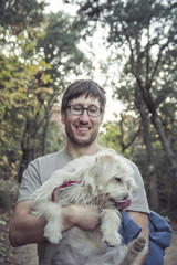 Young man and his lovely puppy in nature - Autumn season - Friendship - Pet owner playing and having fun with his cute dog