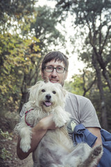 Young man and his lovely puppy in nature - Autumn season - Friendship - Pet owner playing and having fun with his cute dog