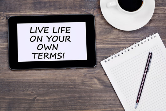 Live life on your own terms! Text on tablet device on a wooden table