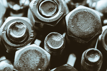 Art monochrome background of bolts and nuts close up in backlight. Small fasteners in macro.