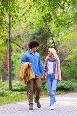 Young cheerful couple walking in the park