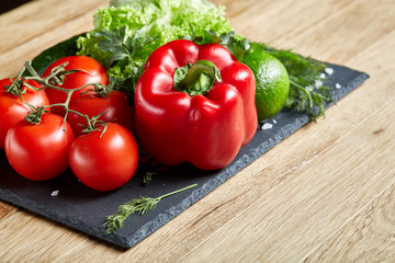 Close-up still life of assorted fresh vegetables and herbs on wooden rustic background, top view, selective focus.