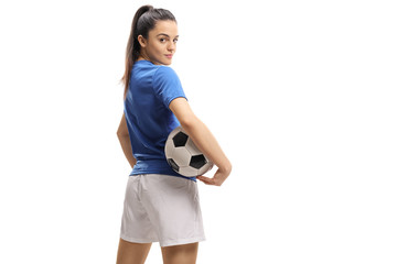 Naklejka premium Female soccer player with a football looking over her shoulder