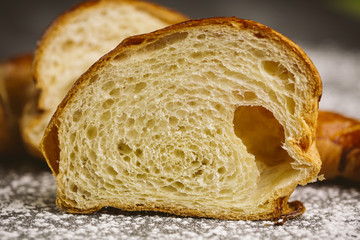 Croissant placed on a plate on a dark background.
