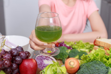hand holding vegetable juice in kitchen