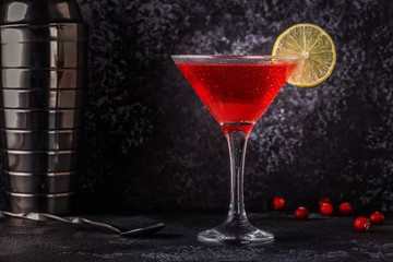 Glass of cosmopolitan cocktail decorated with lime