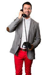 Fototapeta premium Happy Handsome man talking to vintage phone on isolated background