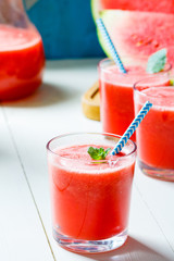 Fresh watermelon smoothies, glasses is standing on wooden table.