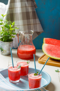 Fresh watermelon smoothies, glasses is standing on wooden table.