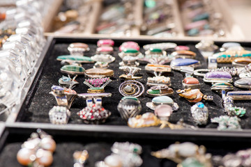 Shot of expensive gemstone jewelry. Rings made of amethyst, sapphire, rose quartz, moonstone, blue topaz, tanzanite, chrysoprase, diamond, charoite stones. Powerful, healing crystals, black background