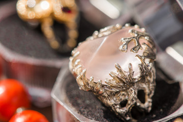 Macro shot of silver engagement ring in gift box on colorful, sparkling background. Rose Quartz Crystal is rose pink colored quartz that aids all types of relationships. powerful healing crystal