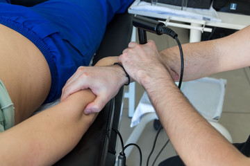 Physiotherapist doing Tecar therapy (Radio Frequency Transporter) alterantive treatment on a woman patient