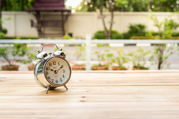 The clock is placed on a wooden table in the evening.