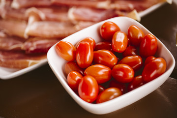 Cherry tomatoes. Cherry tomatoes in ceramic bowl on wooden background.