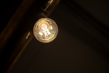 A bright bulb in the middle of the night hung on a ceiling