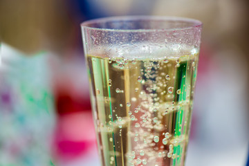 New year celebration. Lipstick imprints on champagne glass full of sparkling wine. Cheerful bride and bridesmaids party