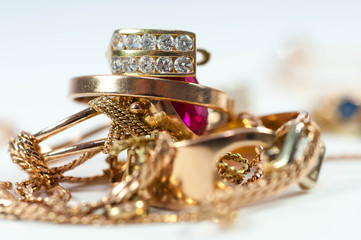 Gold ear ring on gold rings and chain isolated on white background.