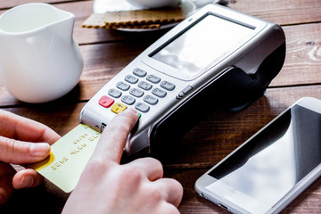 Payment in cafe concept with card and terminal on wooden backgro