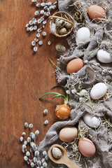 Top view of Easter eggs, pussy willows and feathers. Easter concept on a vintage wooden background. Greeting card, background, space for text