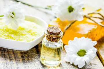 Obraz na płótnie Canvas homemade cosmetics with camomile herbs on wooden background