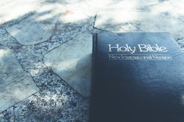 The Holy Bible " The Words of God" on the marble table .Vintage Tone.