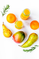 bottles of smoothie with fruits on white table top view