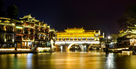 Fenghuang, phoenix ancient town, night view with reflections of the town on the river