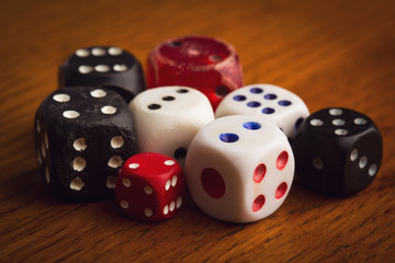 different size and color rolling dices on wooden background