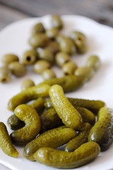 Gherkins and olives in a plate on the table  