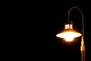 A Bright lamp post emitting on a dark background 