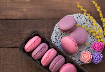 macaroons in a box on a wooden background with a napkin.