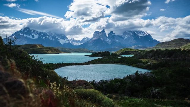 Torres del Paine National Park. Timelapse of the running clouds in mountains with lakes and meadow on the foreground, Patagonia, Chile