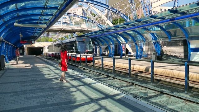 Czech Republic, Prague. May 29, 2017. Cute girl on the platform is auditing the arrival of the train. Railway station, public transport stop, modern architecture, tram, metro, train and transport