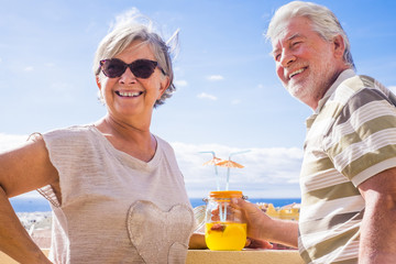 SENIOR COUPLE DRINKING in terrace rooftop