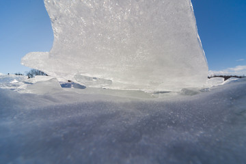 texture of frozen water in a winter lake against a blue sky background 