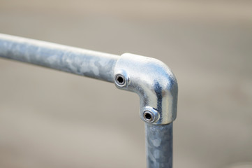 railing made of metal stainless steel pipes. Street. Fastening area with a bolt