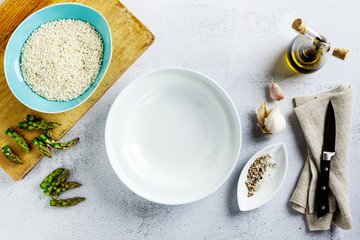 Fototapeta premium empty white plate and ingredients on a white kitchen table. copy space, shot from above