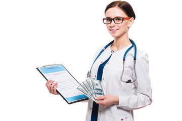 Young beautiful female doctor holding clipboard and money in her hands on white background