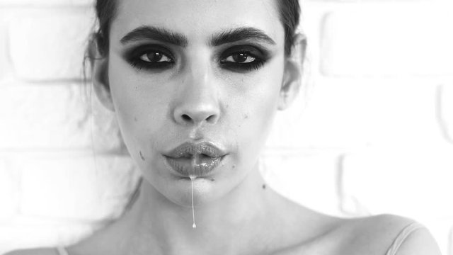 Girl split saliva. Fashion girl with saliva. Young girl. Young woman splits saliva.